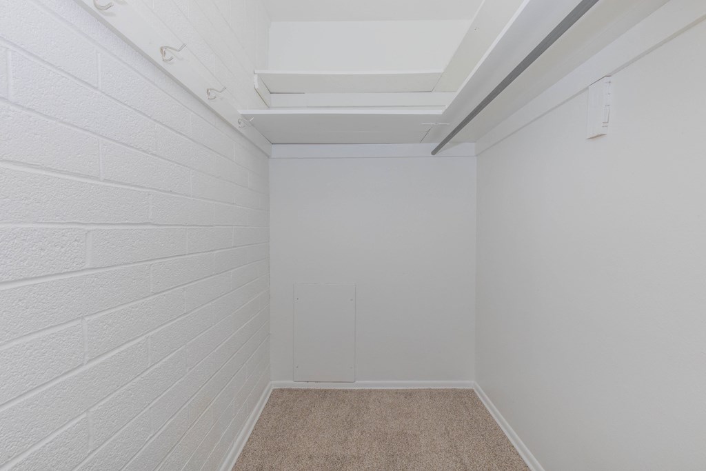 A white room with a carpeted floor and white walls.