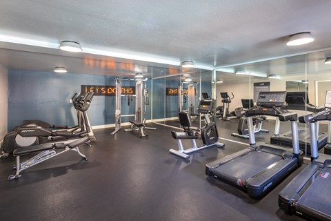 A gym with treadmills, exercise bikes, and other equipment.