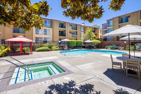 A pool area with a red gazebo and a table with chairs.
