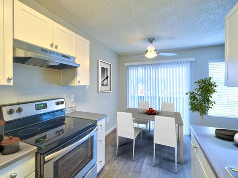 furnished kitchen and dining room with stainless steel appliances and white cabinets