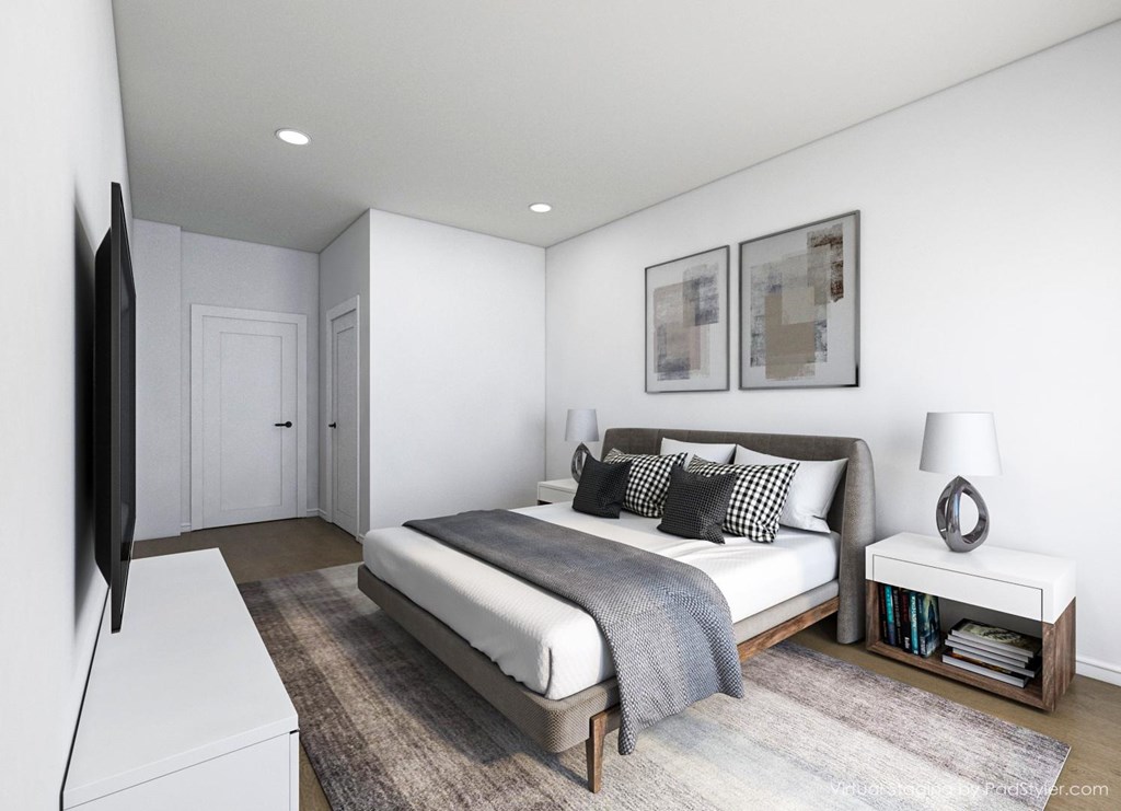 A bedroom with a bed, a television, and a nightstand.