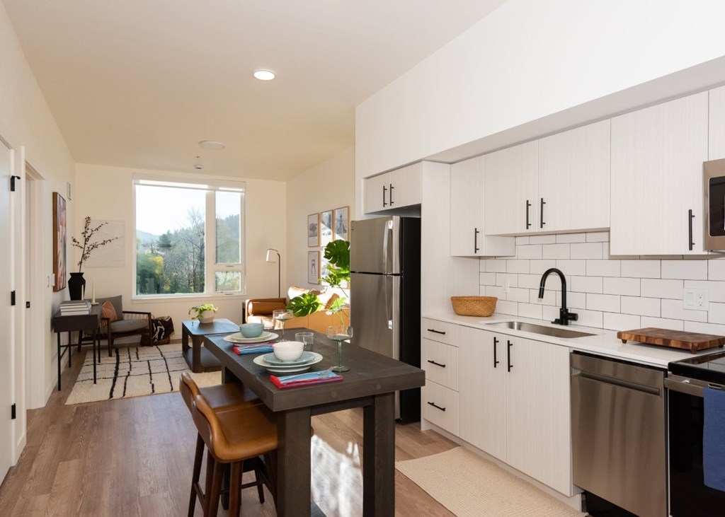 Arts Plaza Gresham Oregon Apartments A modern kitchen with a dining table and chairs.