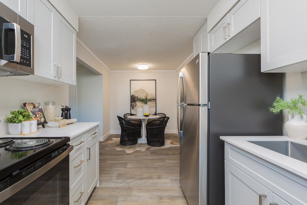 a kitchen with stainless steel appliances and a dining room with a table