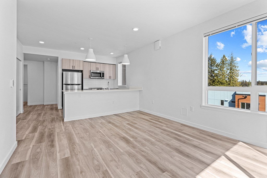 a living room with a kitchen and a large window