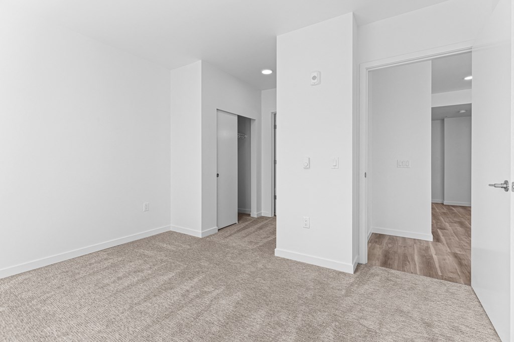 a living room with white walls and a carpeted floor