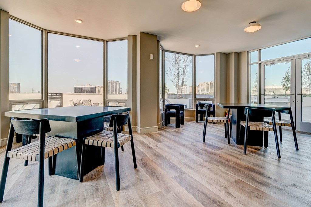 a dining area with tables and chairs and large windows