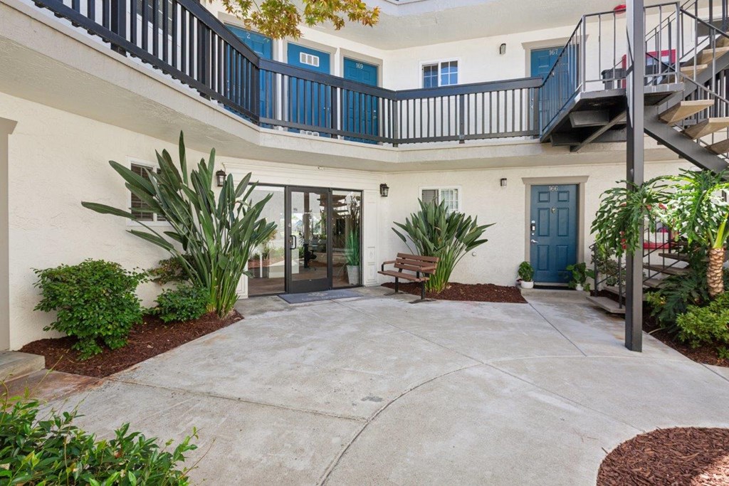 A courtyard with a bench and plants.
