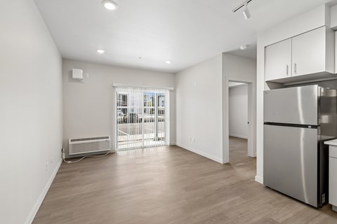 A kitchen with a refrigerator, sink, and cabinets.