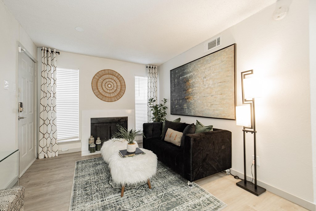 a living room with a black couch and a fireplace