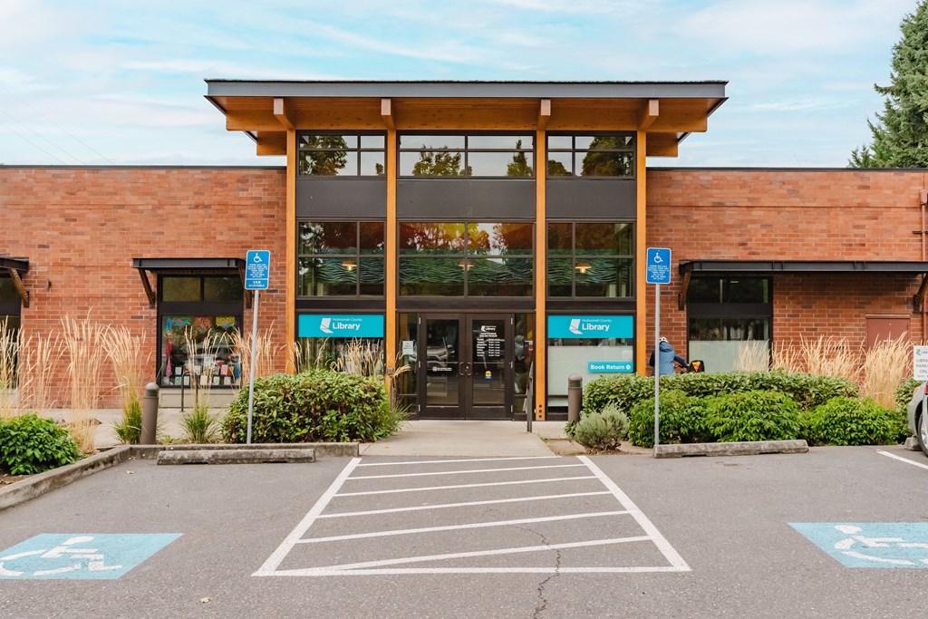 A parking lot with a building entrance and a sign that says