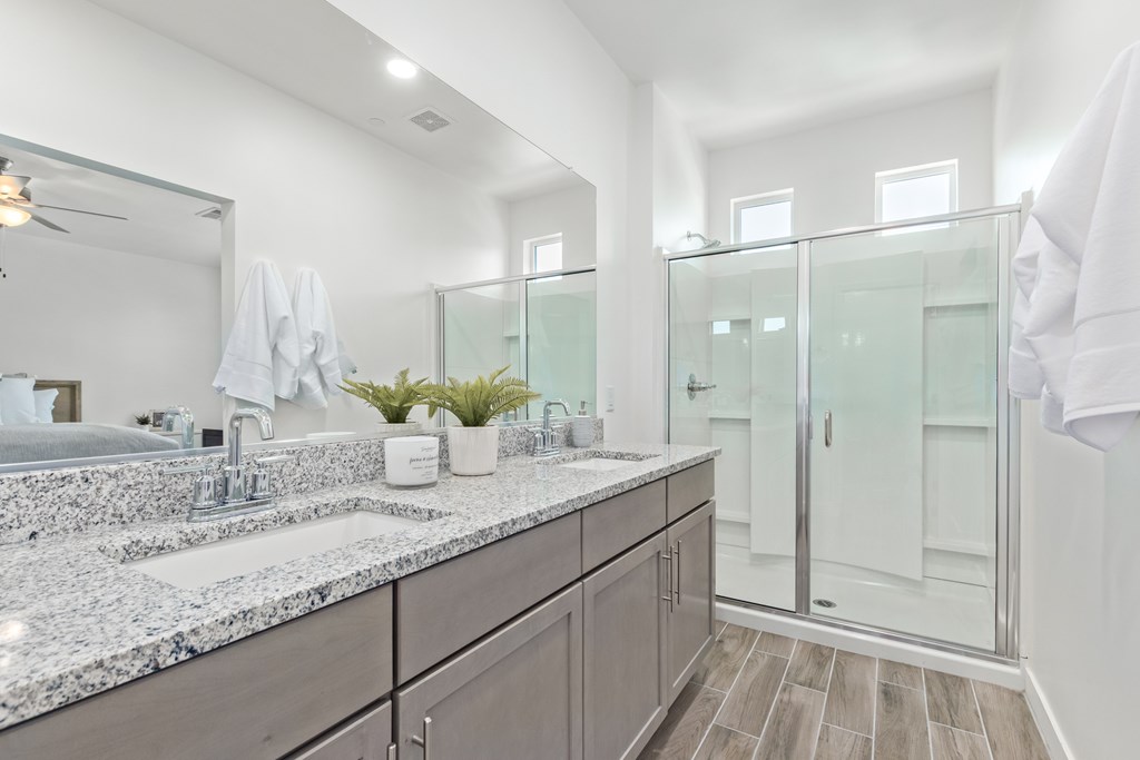A bathroom with a marble countertop and a large mirror.