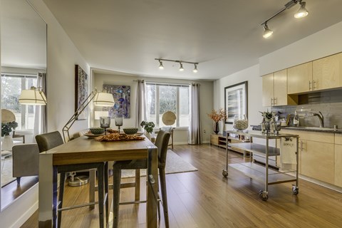 A modern dining room with a wooden table and chairs.