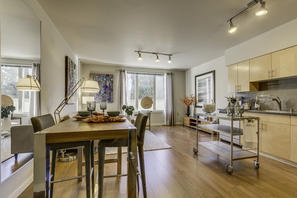 A modern dining room with a wooden table and chairs.