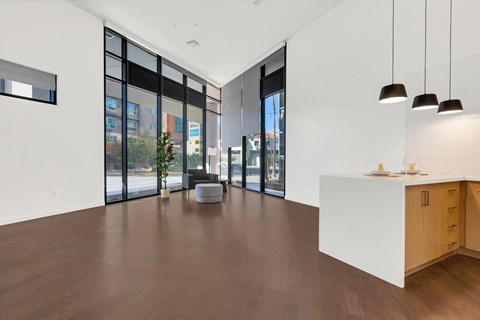 A modern office space with a white reception desk and a large window overlooking the city.