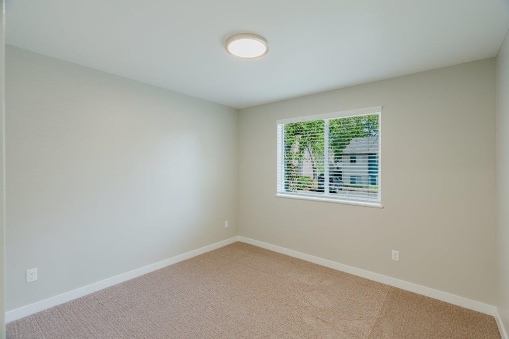 A room with a window and carpeted floor.