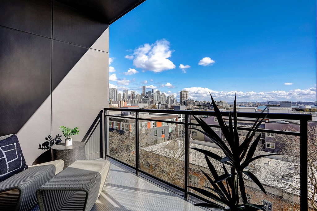 a balcony with a view of a city and a blue sky