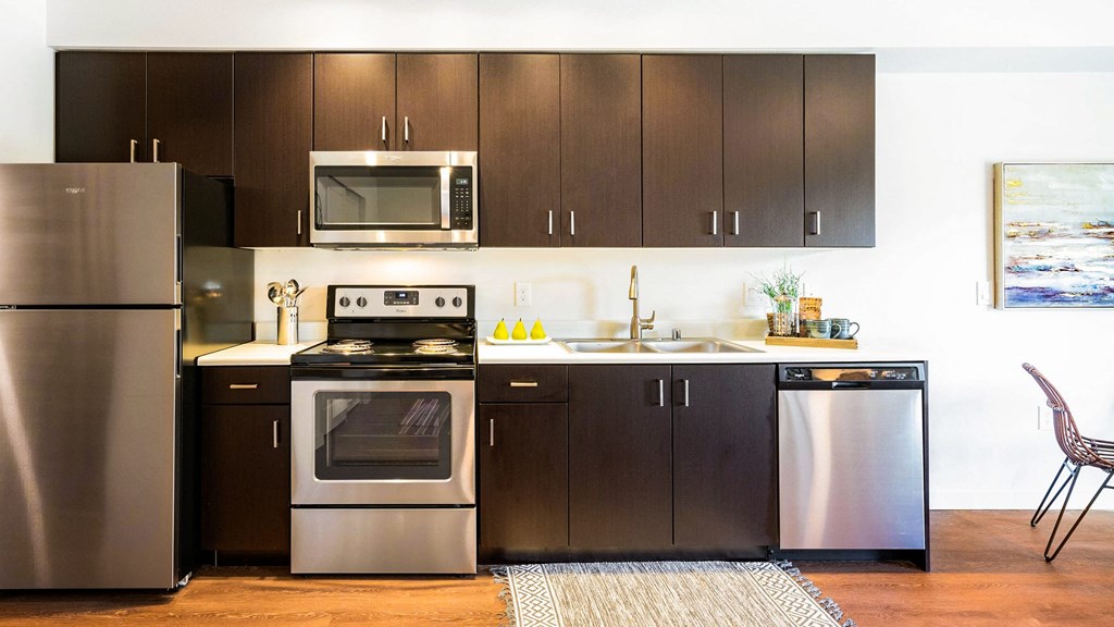 Studio Kitchen with oven, dishwasher, and sink
