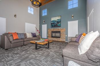A living room with a grey couch, a coffee table, and a fireplace.