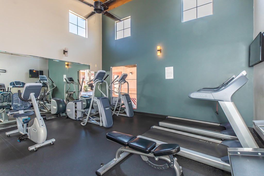 A gym with treadmills, elliptical machines, and other exercise equipment.