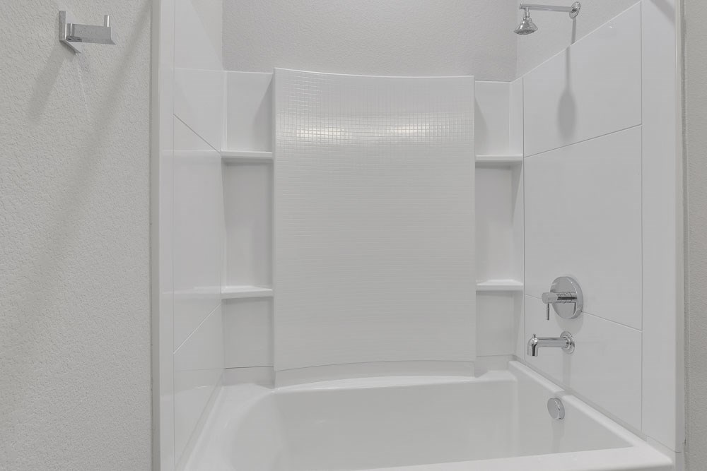 a white bathroom with a shower and a tub