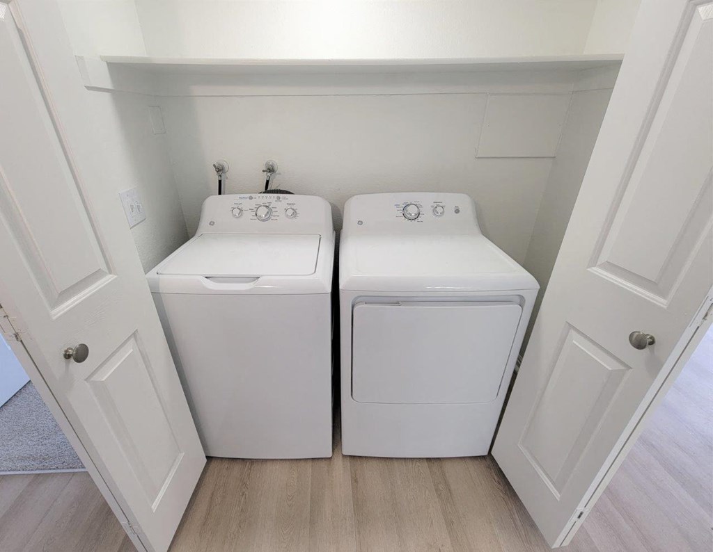 a washer and dryer in a laundry room with white cabinets