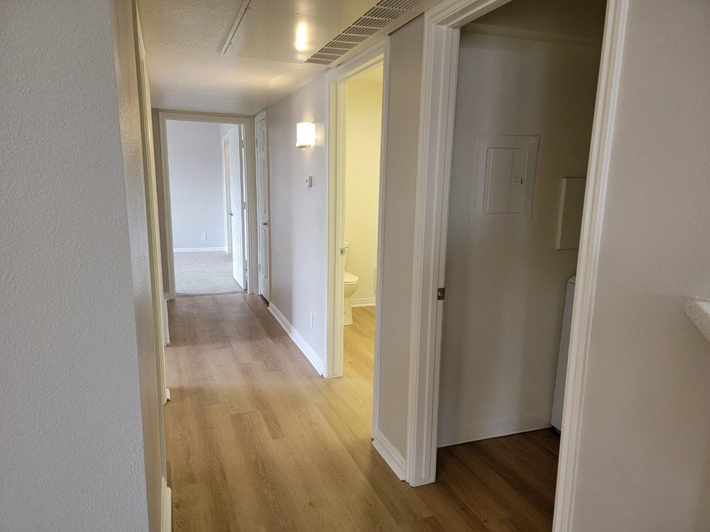 a passageway between two bedrooms and a hallway with a door to a bathroom