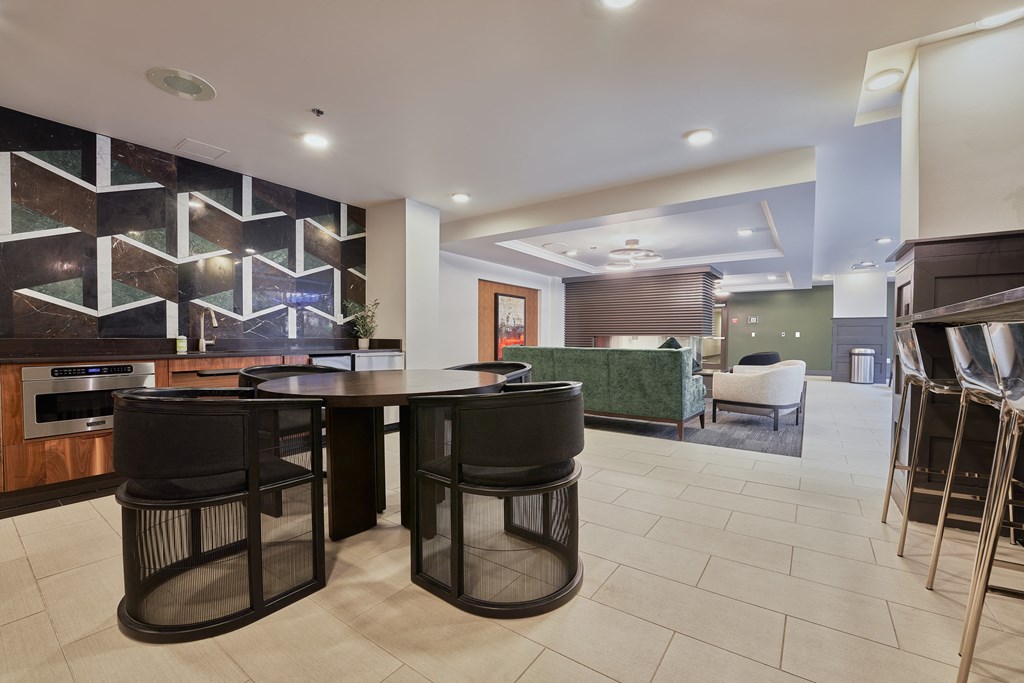 a kitchen with a bar and a dining area with black stools
