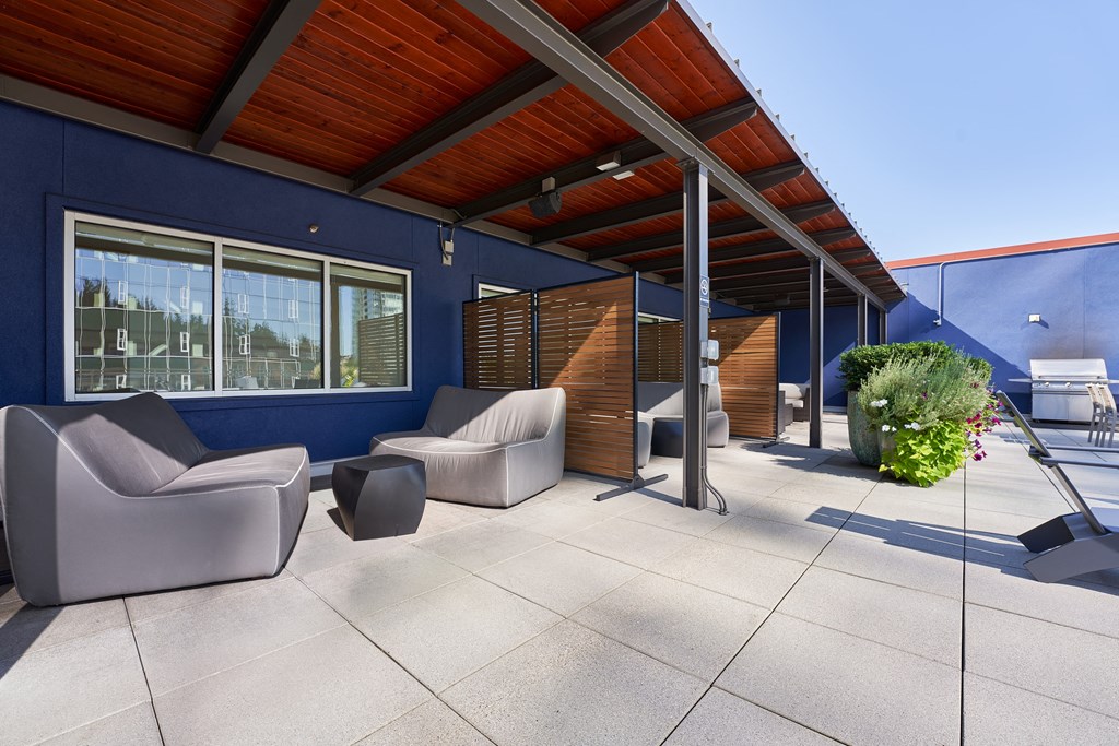 the outdoor patio of the home has couches and chairs and awning