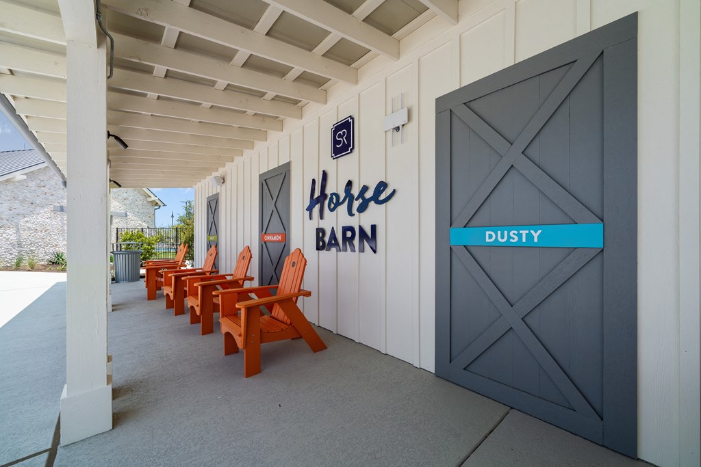 a row of orange chairs outside of a building with a door to a coffee barn