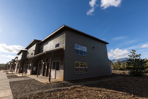 A building with a grey facade and a mountain in the background.