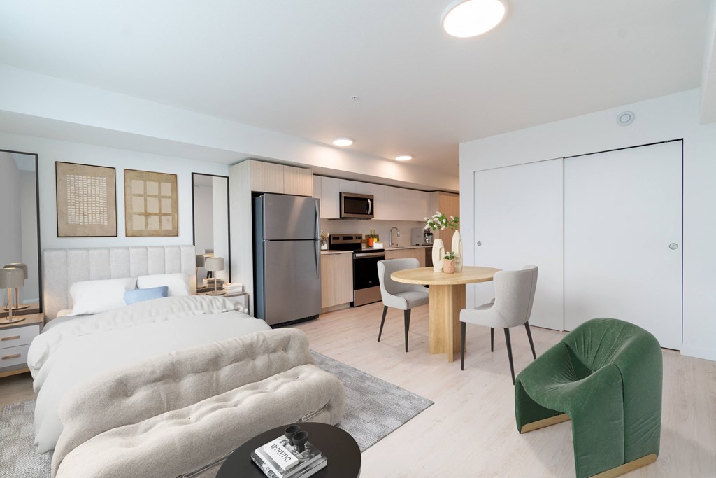 a bedroom with a bed and a table and a kitchen