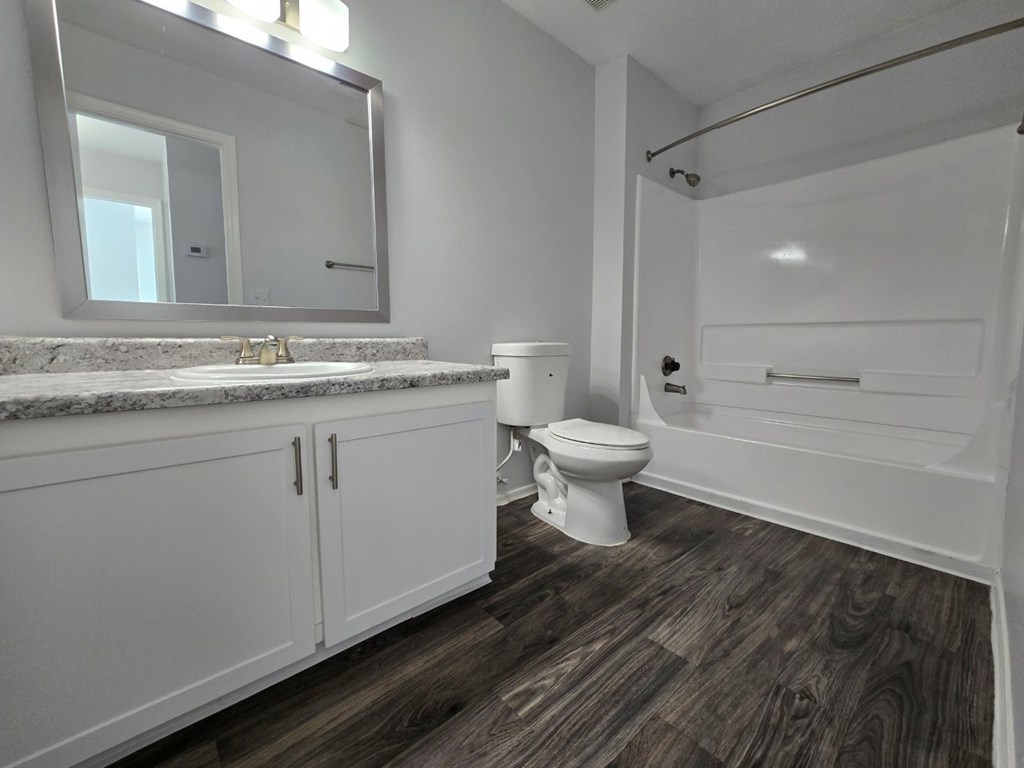 A white bathroom with a toilet, sink, and bathtub.