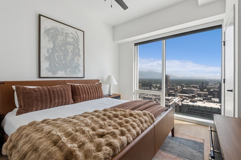 A bedroom with a large bed and a view of the city.