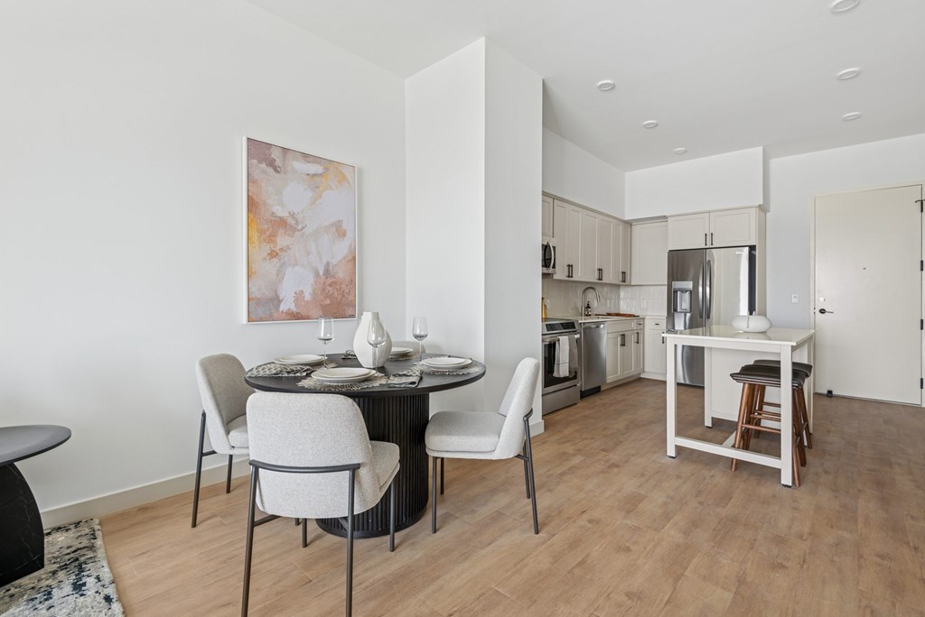 A modern dining room with a round table and chairs.