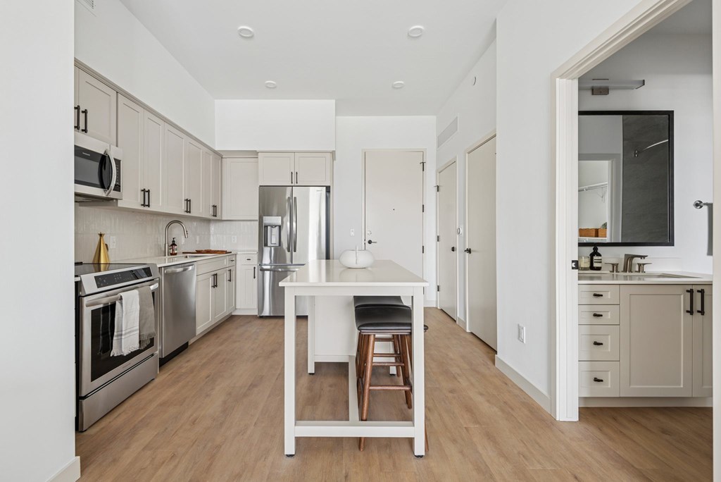 A kitchen with a table and chairs in the middle.
