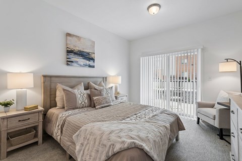 A bedroom with a large bed and a painting on the wall.