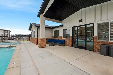 A poolside area with a bench and a building in the background.