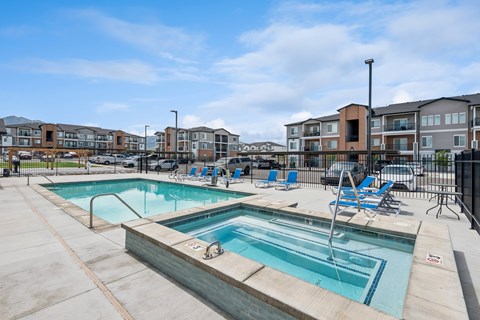 A swimming pool with a slide and chairs around it.