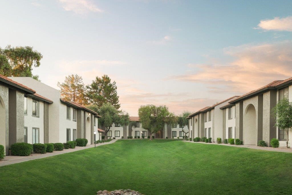 a green lawn in front of a row of houses