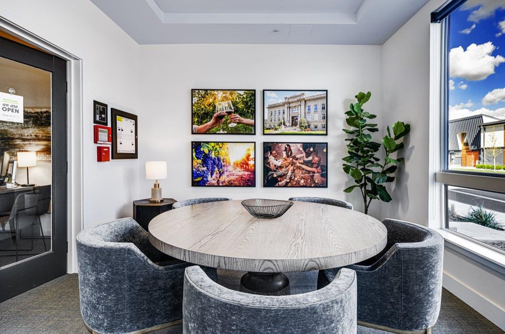 a dining room with a table and chairs and pictures on the wall