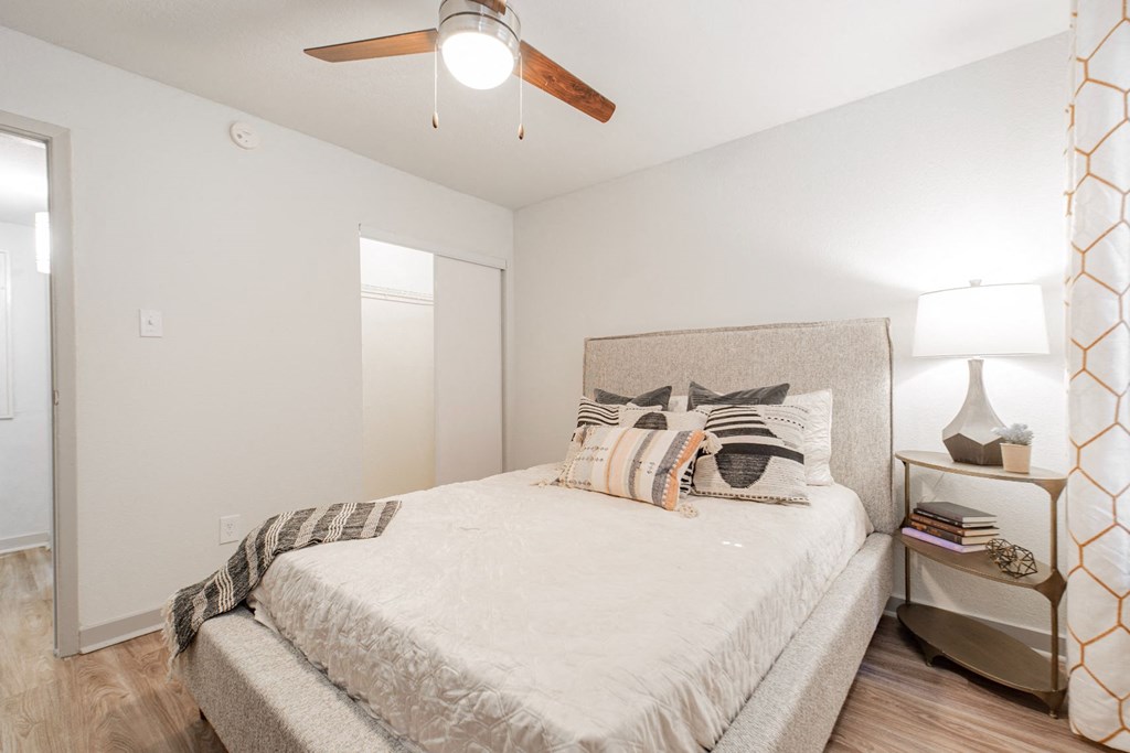 a bedroom with a large bed and a ceiling fan