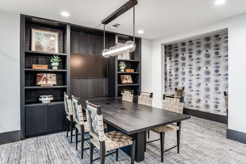 A modern dining room with a dark wood table and chairs.