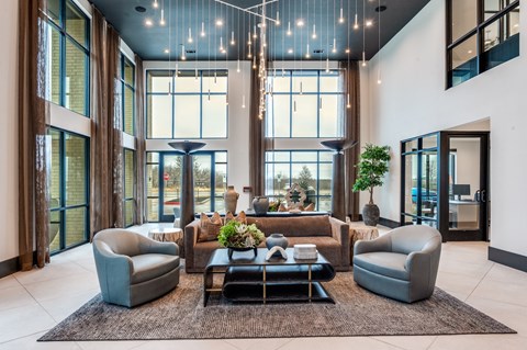 A modern living room with a large window and a rug on the floor.