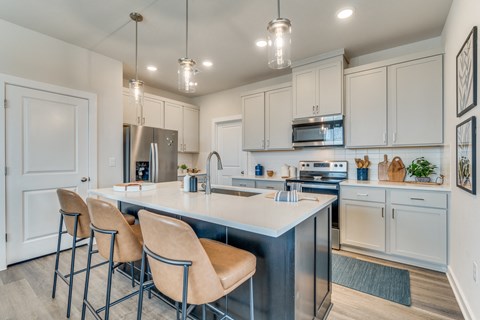 an open kitchen with white cabinets and a large island with four stools