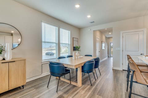 a dining room with a wooden table and blue chairs