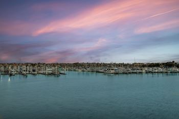 A serene marina at dusk with boats docked in calm waters.