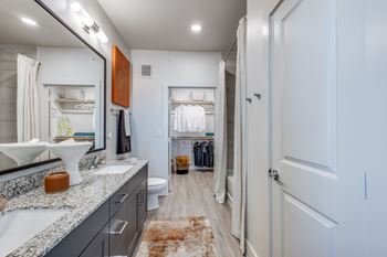 A bathroom with a white sink and a mirror above it.