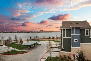A house with a driveway and a beautiful sky in the background.