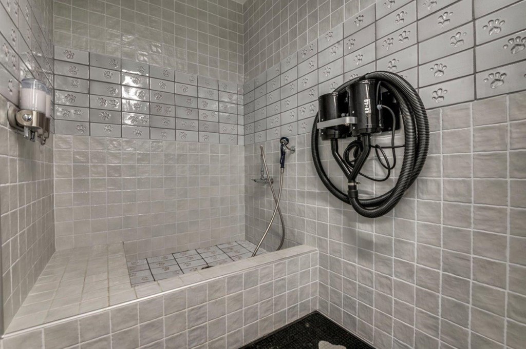 A bathroom with a shower and a hose.