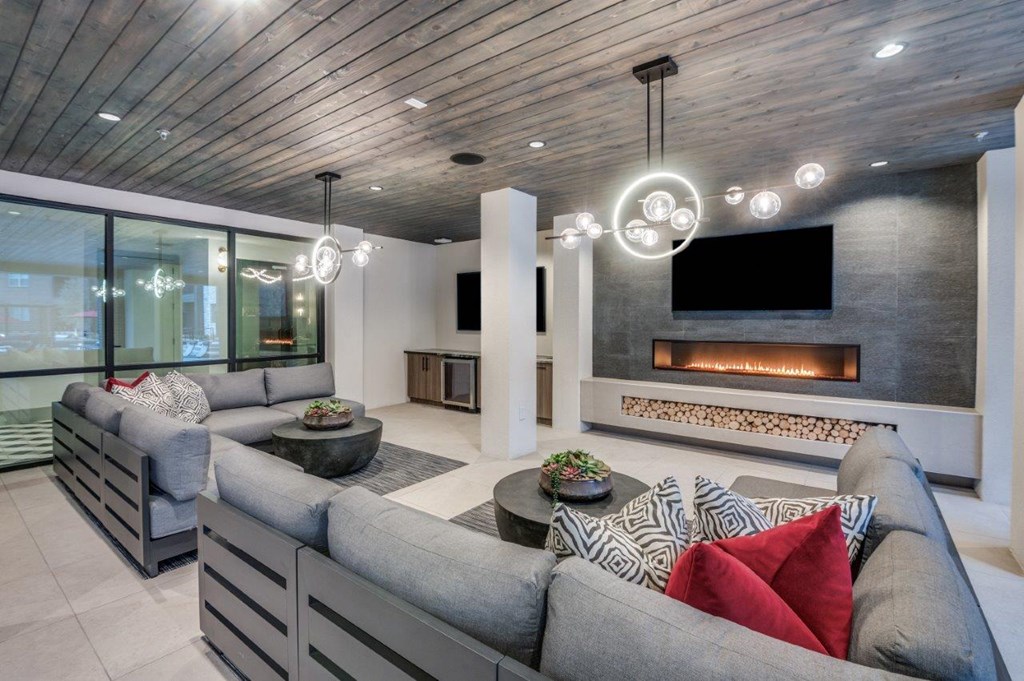 A modern living room with a grey sofa and a fireplace.